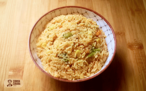 Plato de arroz con vegetales servido, arroz suelto con vegetales visibles y colores variados.