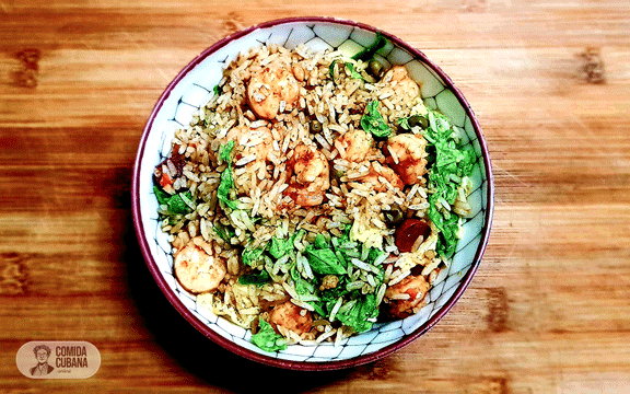 Plato de arroz salteado con camarones servido, arroz suelto con camarones visibles y aspecto dorado.