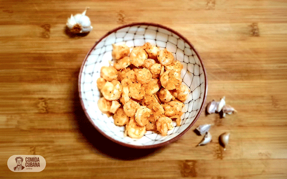 Plato de camarones al ajillo servido, camarones jugosos con salsa de ajo visible