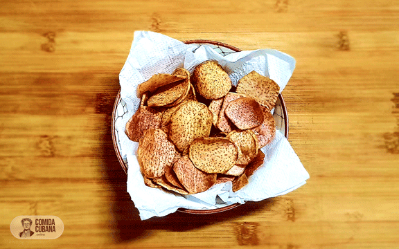Plato de chicharritas de malanga servido, láminas finas fritas doradas y crujientes