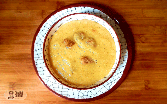 Bol de harina de maíz servida con pedacitos de empella de cerdo por encima, textura amarilla visible