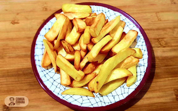 Plato de papas fritas servido, papas doradas y crujientes con textura visible