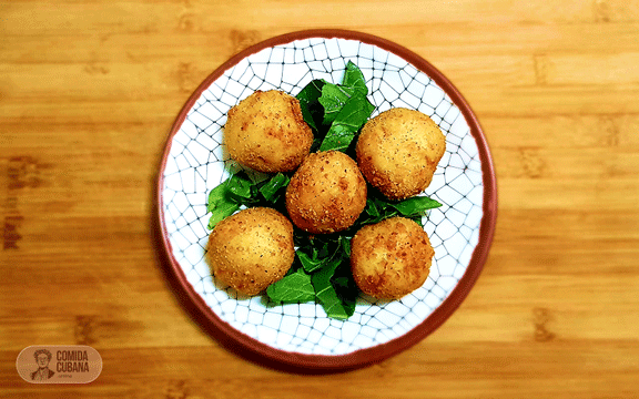 Plato de papas rellenas servido, piezas doradas con textura crujiente visible