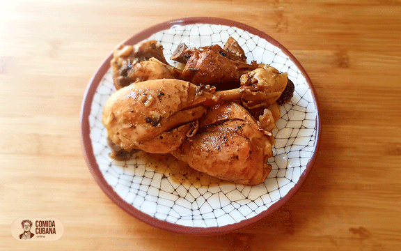 Plato de pollo al vino servido, piezas de pollo en salsa oscura con aspecto reducido y brillante